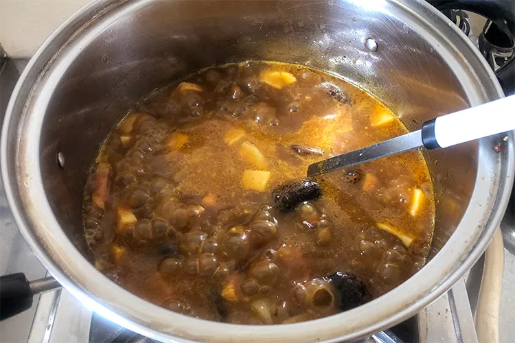 花豆のアヒージョを鍋に入れてカレーを作る様子