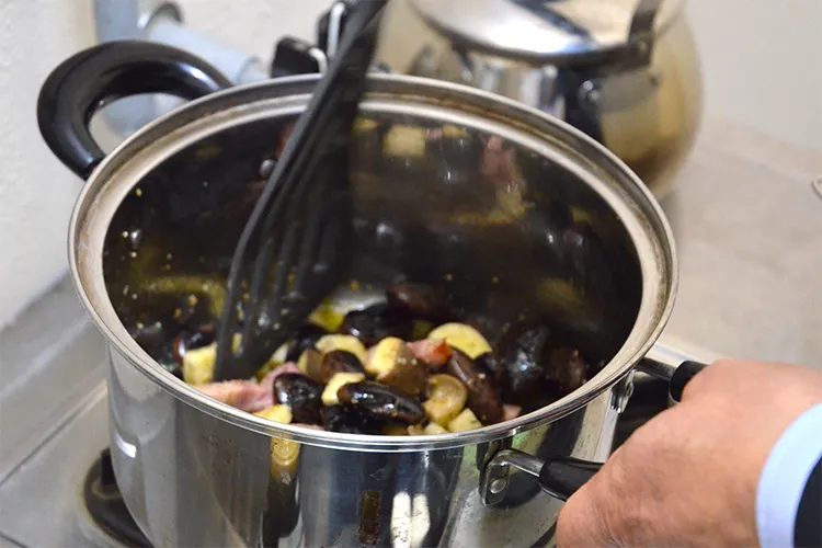 エリンギとベーコン、花豆を鍋の中で炒める様子