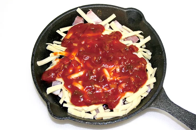 ミックスチーズの上にピザソースがかけられた様子