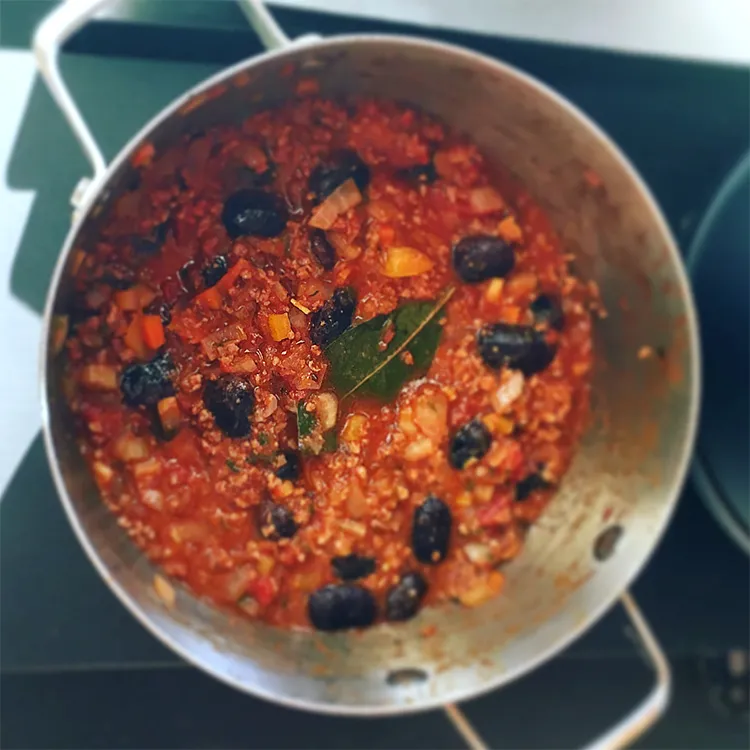 具と煮汁に花豆を加えて鍋で煮る様子