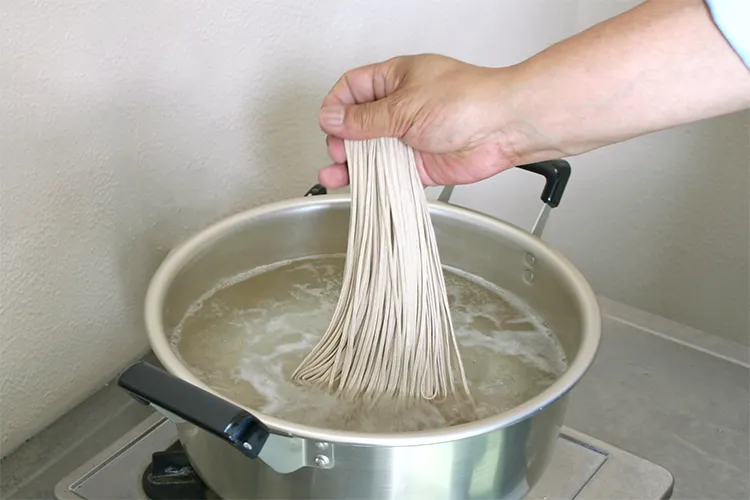 本十割生そばを鍋に投入する様子