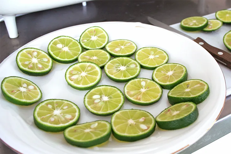 輪切りにしたすだちが皿いっぱいに盛られている様子